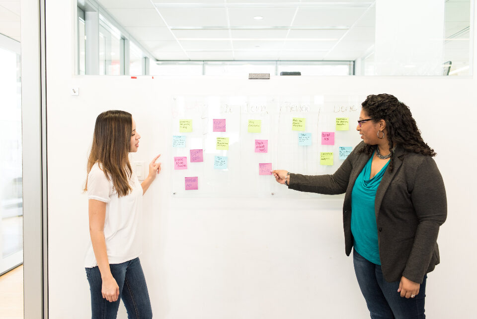 Colleagues working through a plan at a whiteboard